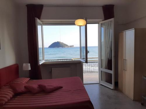 a bedroom with a large window looking out at the ocean at Residence Sole in Albenga
