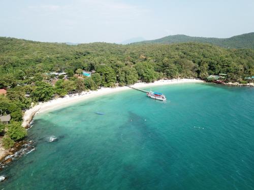 un barco en el agua junto a una playa en Samed Tropical Resort, en Ko Samed