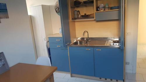 a small kitchen with blue cabinets and a sink at Attico mansardato davanti Casinò in Sanremo