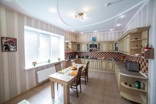 uma cozinha com uma mesa e cadeiras em HOLLYWOOD em Poltava