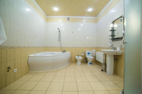 a bathroom with a tub and a toilet and a sink at HOLLYWOOD in Poltava