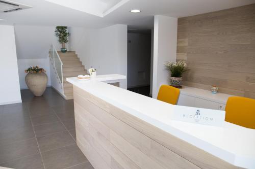 an office with a reception counter and orange chairs at Hotel Grel in Chiaramonte Gulfi