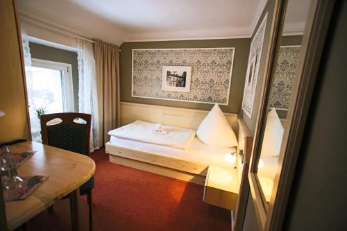 ein Hotelzimmer mit einem Bett, einem Tisch und einem Fenster in der Unterkunft Hotel-Restaurant Alter Krug Kallinchen in Kallinchen