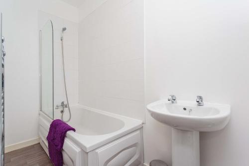 a white bathroom with a sink and a bath tub at Cherry Property - Plum Suite in Blackpool