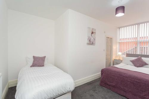 a bedroom with two beds and a window at Cherry Property - Plum Suite in Blackpool