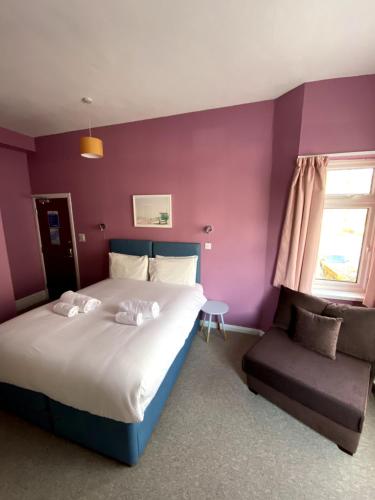 a bedroom with a large bed and a chair at WiseStay in Cardiff