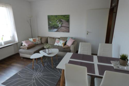 - un salon avec un canapé, une table et des chaises dans l'établissement Apartment Johanna, à Braunlage