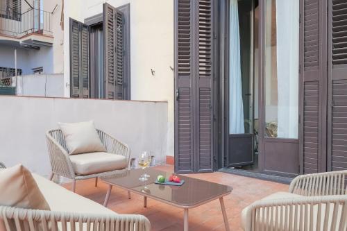 un patio con sillas y una mesa con una copa de vino en Sweet Inn - Sepulveda, en Barcelona