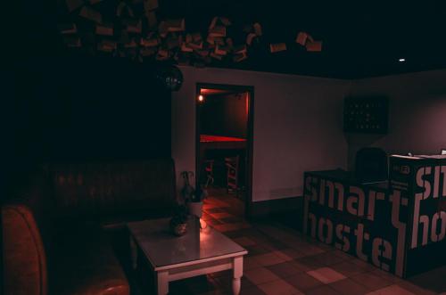 a dark room with a table and a shelf with wine bottles at Smart Hostel in Odesa