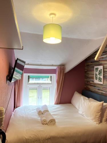 a bedroom with a bed with towels on it at WiseStay in Cardiff