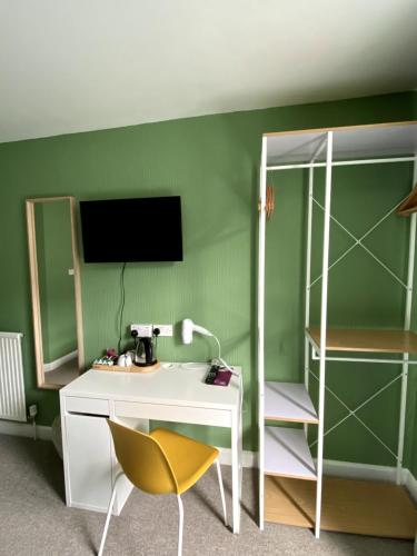 a green room with a desk and a yellow chair at WiseStay in Cardiff