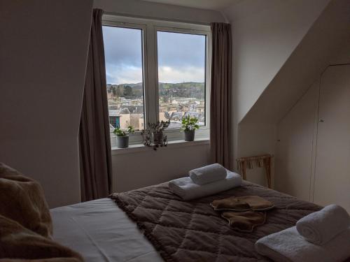 a bedroom with a bed with two pillows and a window at Central Hawick spacious stylish flat with log burner in Hawick