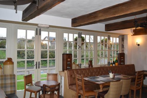 a dining room with windows and a table and chairs at Three Horseshoes Country Inn in Barry