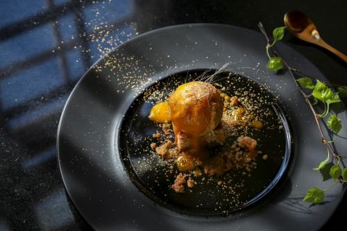 a black plate with food on a table at Malpils Manor in Mālpils