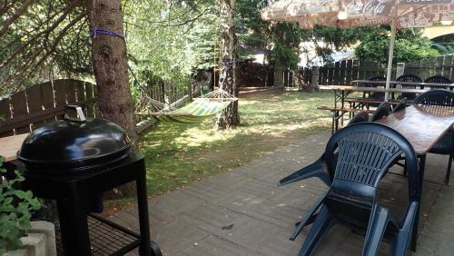 a patio with a hammock and a table and a grill at Pension Fortuna in Halenkov