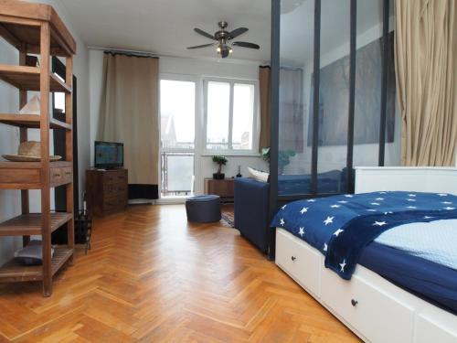 a bedroom with a bed with a blue comforter at Grand-Tourist Apartment - Gold in Gdańsk