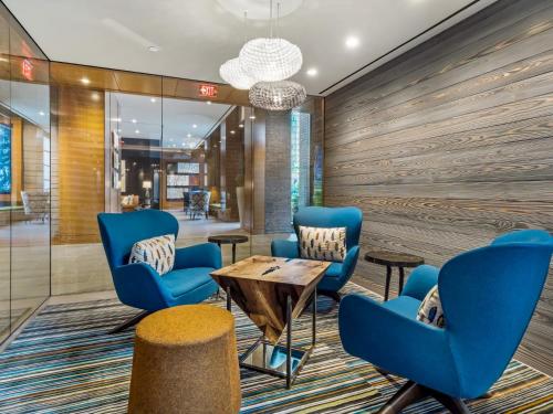 a lobby with blue chairs and a wooden wall at Global Luxury Suites at Reston Town Center in Reston