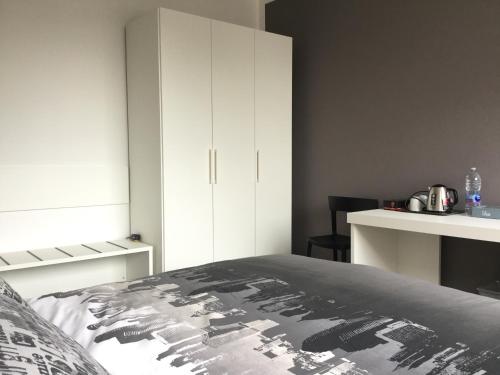 SUB 14 Suite Apartment - Vietato Fumare في ريجيو إيميليا: غرفة نوم بسرير ودواليب بيضاء
