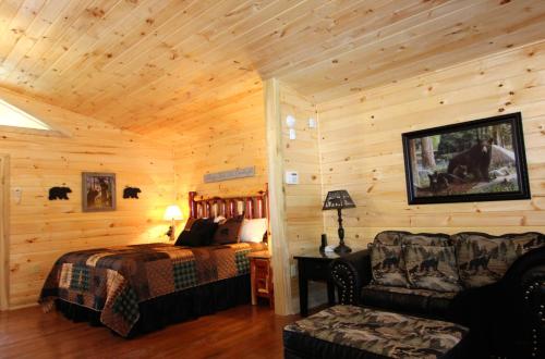 uma cabina de madeira com uma cama e uma cadeira em Mountain Magic em Gatlinburg