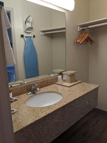 a bathroom counter with a sink and a mirror at Atrium Inn in Fort Stockton