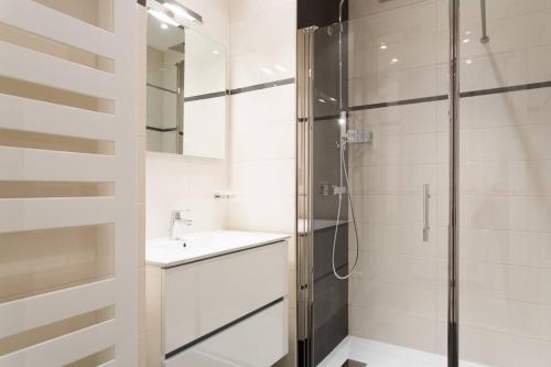 une salle de bain blanche avec une douche et un lavabo dans l'établissement Palais Miramar Croisette 1 bedroom, à Cannes