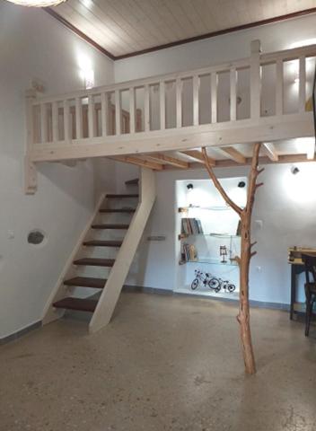a loft bed with a staircase in a room at Imellos in Apeiranthos