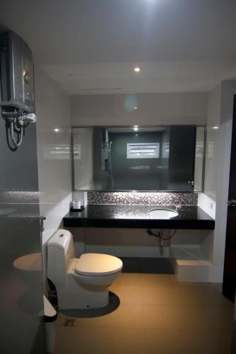 a bathroom with a toilet and a sink at Smith Residence in Suratthani
