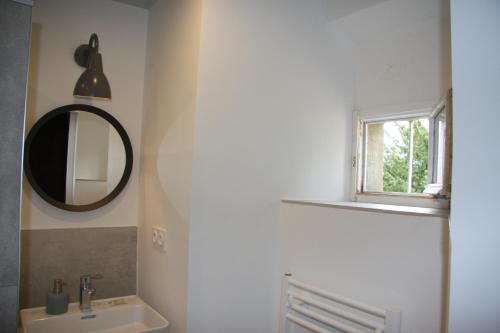 baño con lavabo, espejo y ventana en Château La Violette en Les Marches