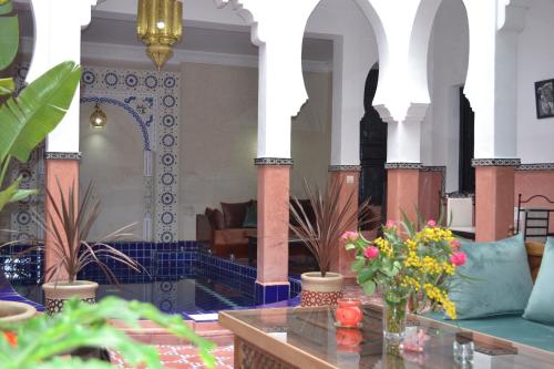 - un hall avec une table et des fleurs dans l'établissement Riad le Voile d'Orient, à Marrakech