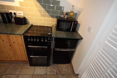 a kitchen with a black stove and a counter at Lynton Lodge Studios in Keswick