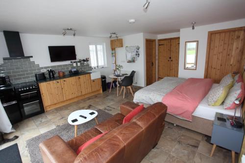 a living room with a bed and a couch at Lynton Lodge Studios in Keswick