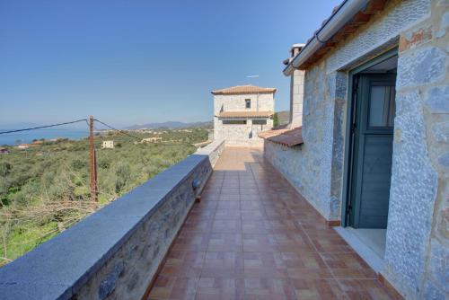 a walkway to a house with a building in the background at Mani Stone Towers in Kotrónion