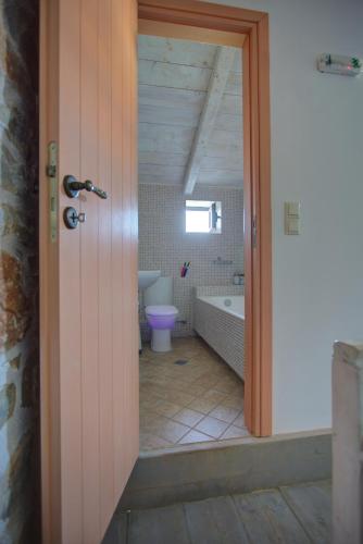 a bathroom with a bath tub and a toilet at Mani Stone Towers in Kotrónion