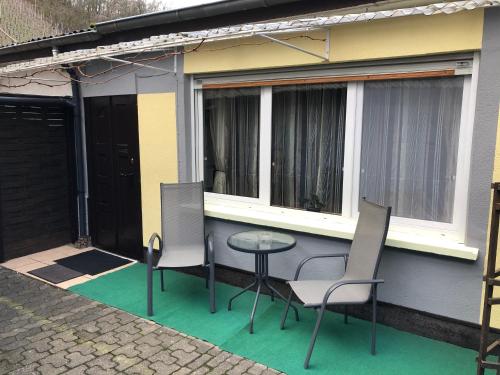 eine Terrasse mit 2 Stühlen und einem Tisch vor einem Haus in der Unterkunft Ferienwohnung Ziemons in Cochem