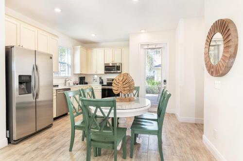 a kitchen with a table and chairs and a refrigerator at Margaritaville Cottages Orlando with H2O Waterpark by Rentyl in Kissimmee