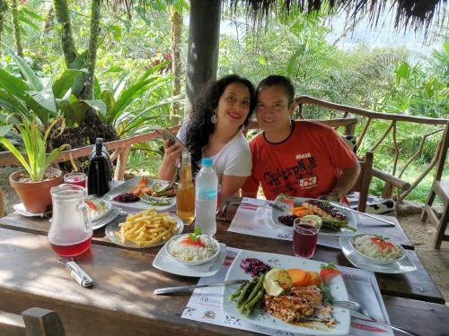 a man and a woman sitting at a table with food at Finca de la Vaca - Family House in Mera