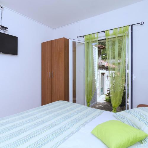 a bedroom with a bed and a large window at Apartments Vitorin in Sobra