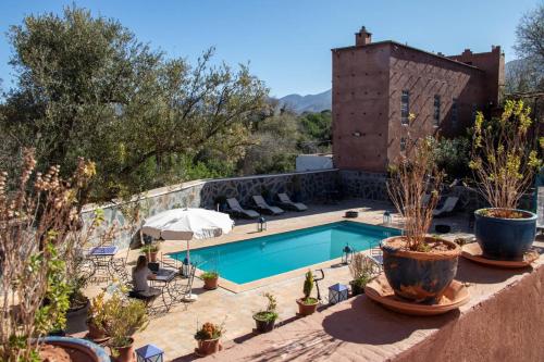 una piscina en un patio con macetas en Riad Malak, en Ouirgane