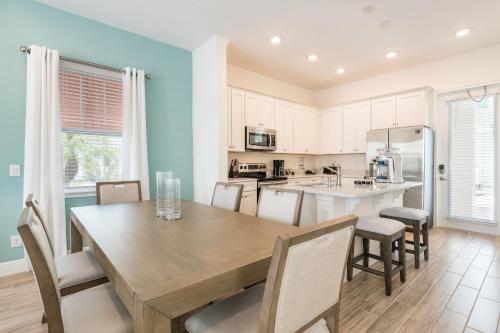 a kitchen and dining room with a wooden table and chairs at Margaritaville Cottages Orlando with H2O Waterpark by Rentyl in Kissimmee