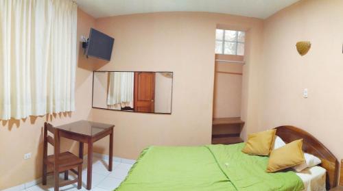 - une chambre avec un lit, une table et un miroir dans l'établissement Alojamiento "Selva Del Sol", à Rioja