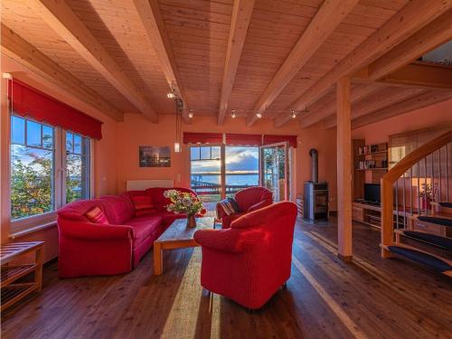 a living room with two red chairs and a table at Ferienhaus Uttied - direkt am Plauer See in Alt Schwerin