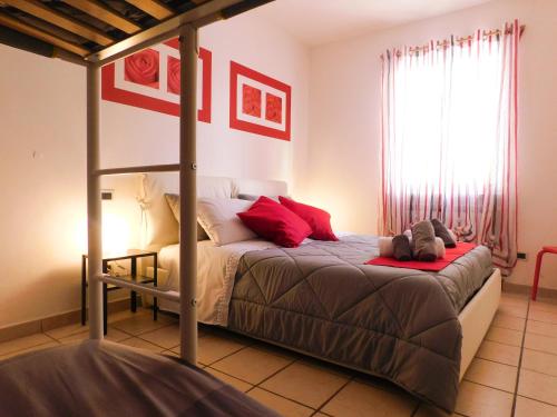 a bedroom with a bed with red pillows at La perla rossa in Arcola