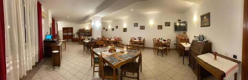 Sînnicolau Mare的住宿－Vila Zoppas Inn，一间在房间内配有桌椅的餐厅