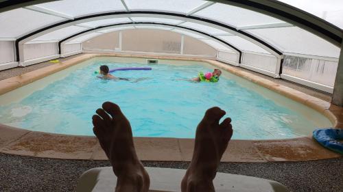 une personne assise sur une chaise dans une piscine dans l'établissement Gites du Combeau, à Saint-Maurice-dʼIbie