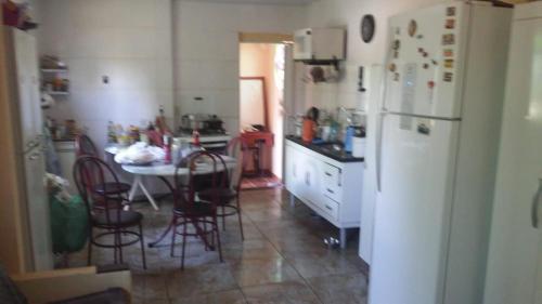 a kitchen with a table and a white refrigerator at Aconchego dos schreiber in Belo Horizonte