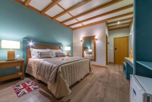 a bedroom with a large bed and a bathroom at Hotel Boutique Britanico in Gramado