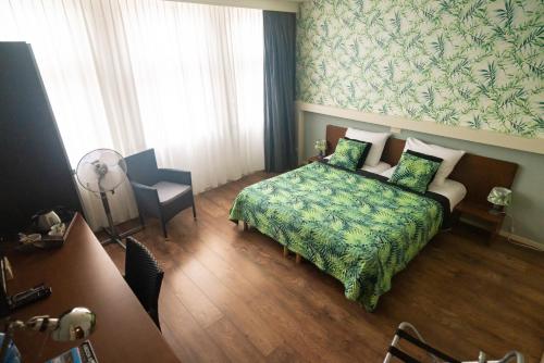 Habitación de hotel con cama y silla en B&B Posthoorn en Hoorn