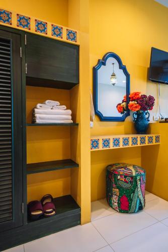 a shelf in a room with a mirror and towels at La Reina Maroc Hotel ปากช่อง เขาใหญ่ in Pak Chong