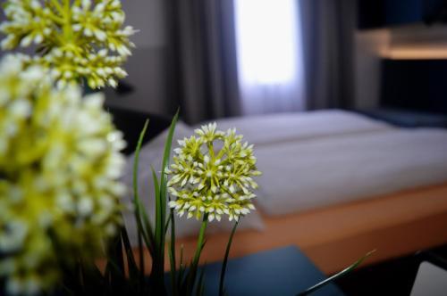 a table with flowers on it with a bed at Pension Elisabeth - Rooms & Apartments in Salzburg