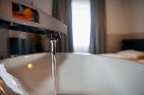 a sink with water running from a faucet at Pension Elisabeth - Rooms & Apartments in Salzburg
